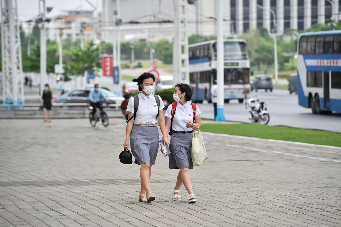 In a photo taken on June 8, 2023, students walk along Changjon Street in Pyongyang.