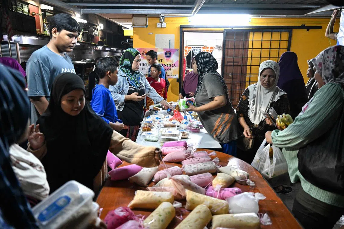 Residents receive unsold food collected from street markets by volunteers of the NGO GEMA Malaysia in Kuala Lumpur during the Islamic holy month of Ramadan on March 18.