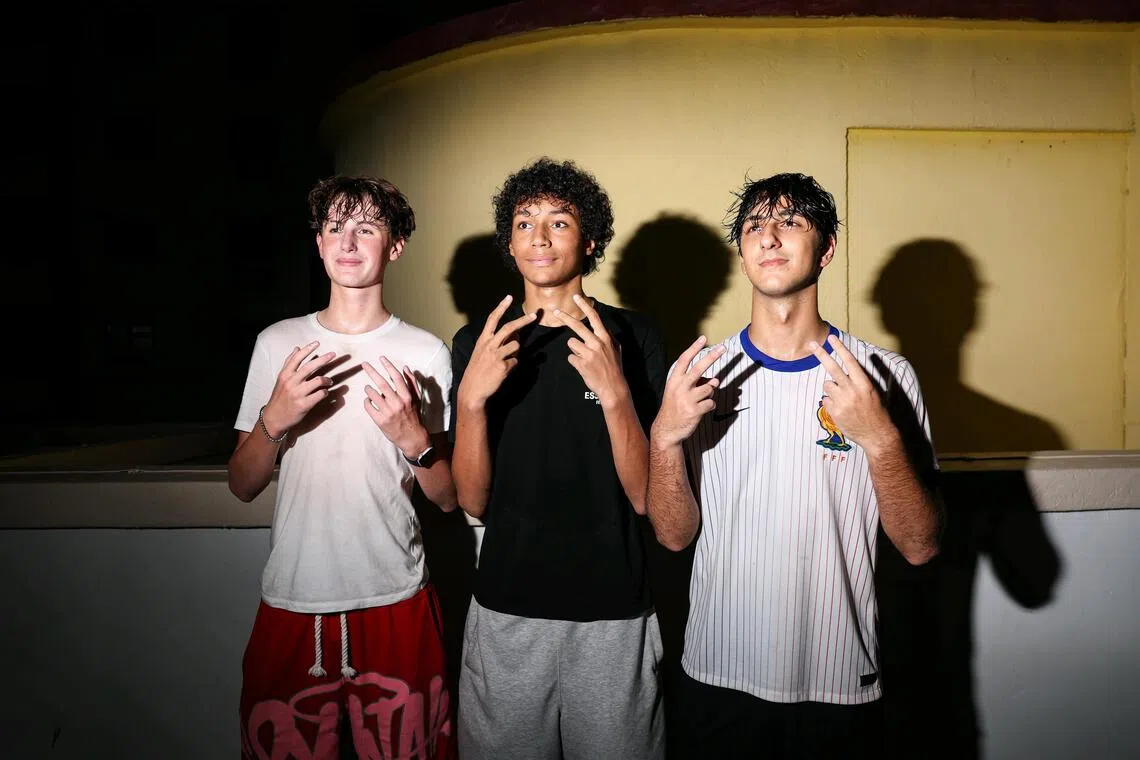 (From left) Tuna Ekmen, 18, Dulwich College student, Micah Brandon Rijke, 16, Chatsworth International School student, and Hugo George Quinn, 15, Chatsworth International School student, gathered at Chinatown Complex basketball court for a glimpse of basketball influencer Matt Kiatipis on Oct 6, 2026. ST PHOTO: BRIAN TEO