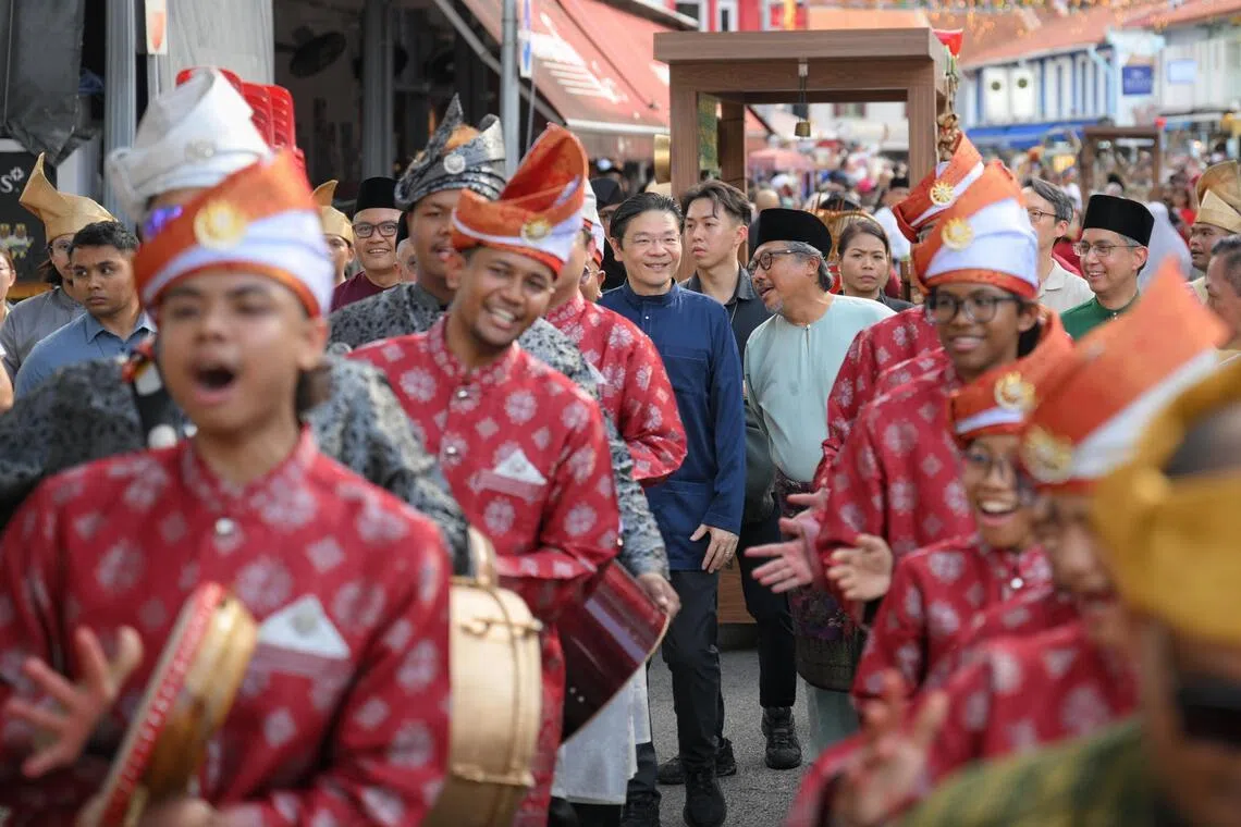 PM Lawrence Wong (centre, left), and Kampong Gelam Alliance chairman Zaki Ma’arof (centre, right) joining performers outside the Malay Heritage Centre during its reopening on April 25.