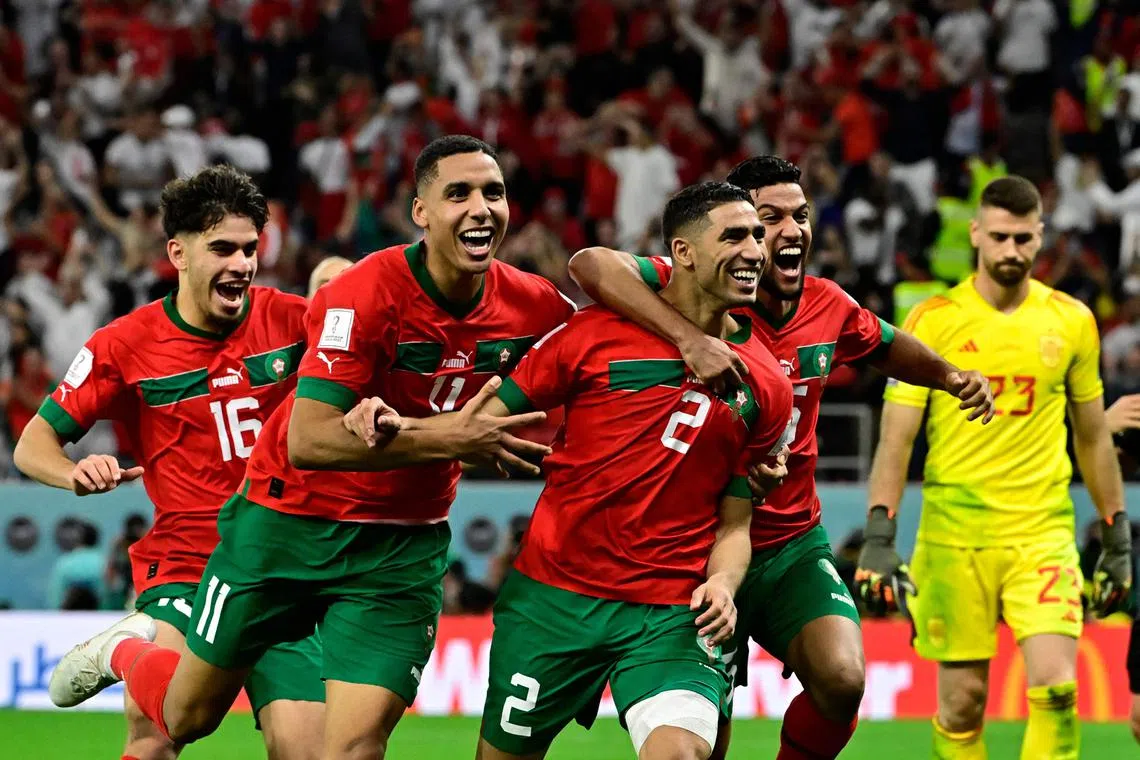 Morocco's defender #02 Achraf Hakimi (2nd R) celebrates with teammates after converting the last penalty during the penalty shoot-out to win the Qatar 2022 World Cup round of 16 football match between Morocco and Spain at the Education City Stadium in Al-Rayyan, west of Doha on Dec 6, 2022. 