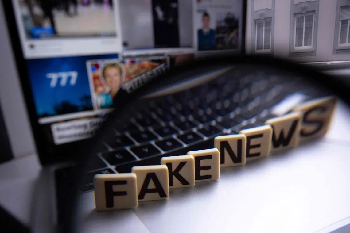 This illustration photograph shows letters reading "fake news" seen through a magnifying glass, against a laptop screen displaying other illustration images of various alleged fake news, disinformation campaigns or conspiracy theories, in Mulhouse, eastern France, on December 1, 2023 .