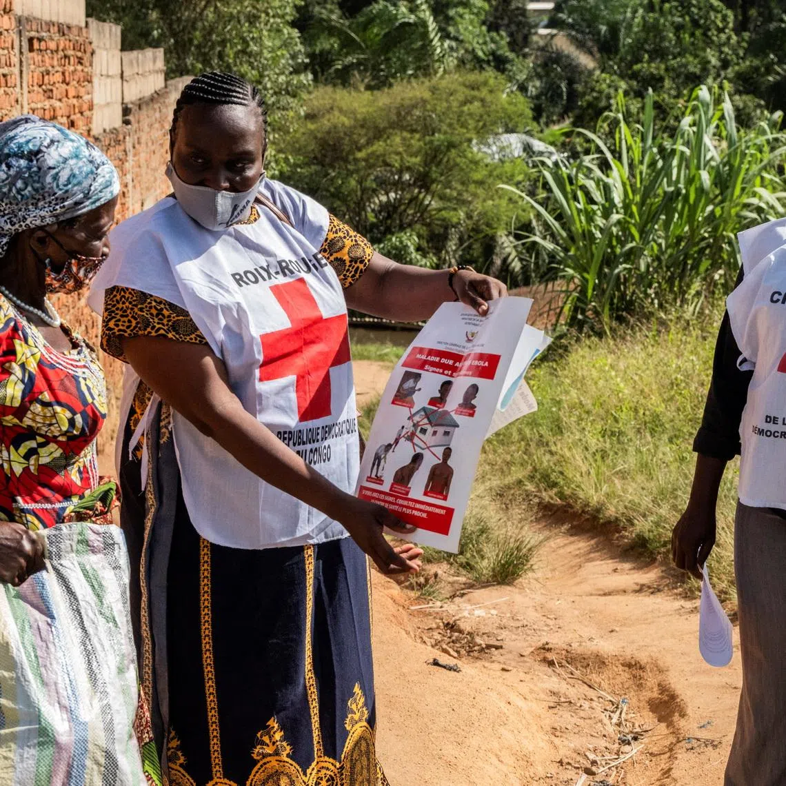 FILE PHOTO: Red Cross outreach workers talk to a woman in a residential area, to raise awareness about Ebola, as aid agencies intensify efforts to contain an Ebola outbreak caused by the Bundibugyo virus in Bunia, Democratic Republic of Congo, May 25, 2026. REUTERS/Stringer/File Photo