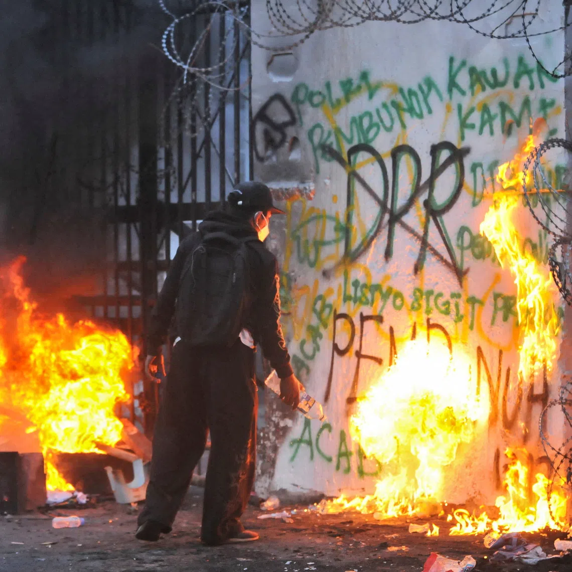 A protester sets fire to the gate of the regional parliament building during a protest against the government's spending priorities, such as enhanced perks for lawmakers, in Bandung, West Java province, Indonesia, September 1, 2025. REUTERS/Bilal Wibisono