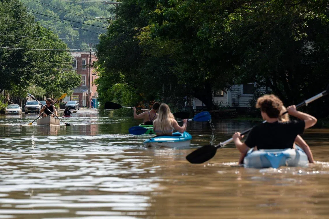 People kayak up and down the flooded waters of Elm Street on July 11 in Montpelier, Vermont. 
