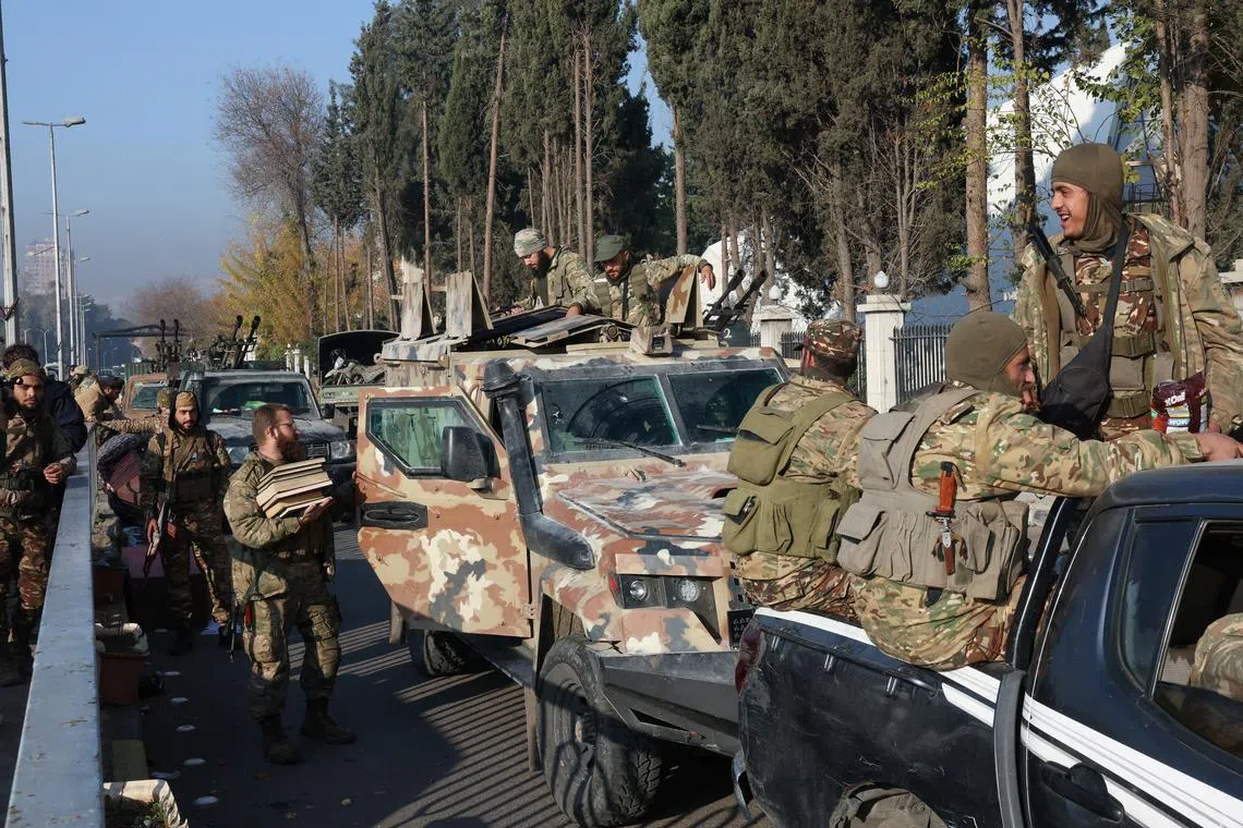 Rebel fighters sit on vehicles, after rebels seized the capital and ousted President Bashar al-Assad, in Damascus, Syria, December 9, 2024. REUTERS/Mohamed Azakir