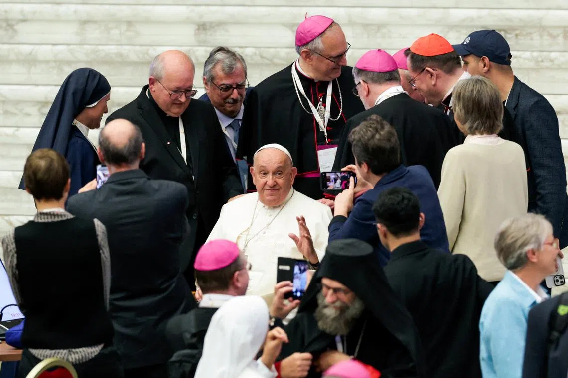 Pope Francis greets participants at the end of the Synod of Bishops at the Paul VI hall at the Vatican, October 26, 2024. REUTERS/Remo Casilli