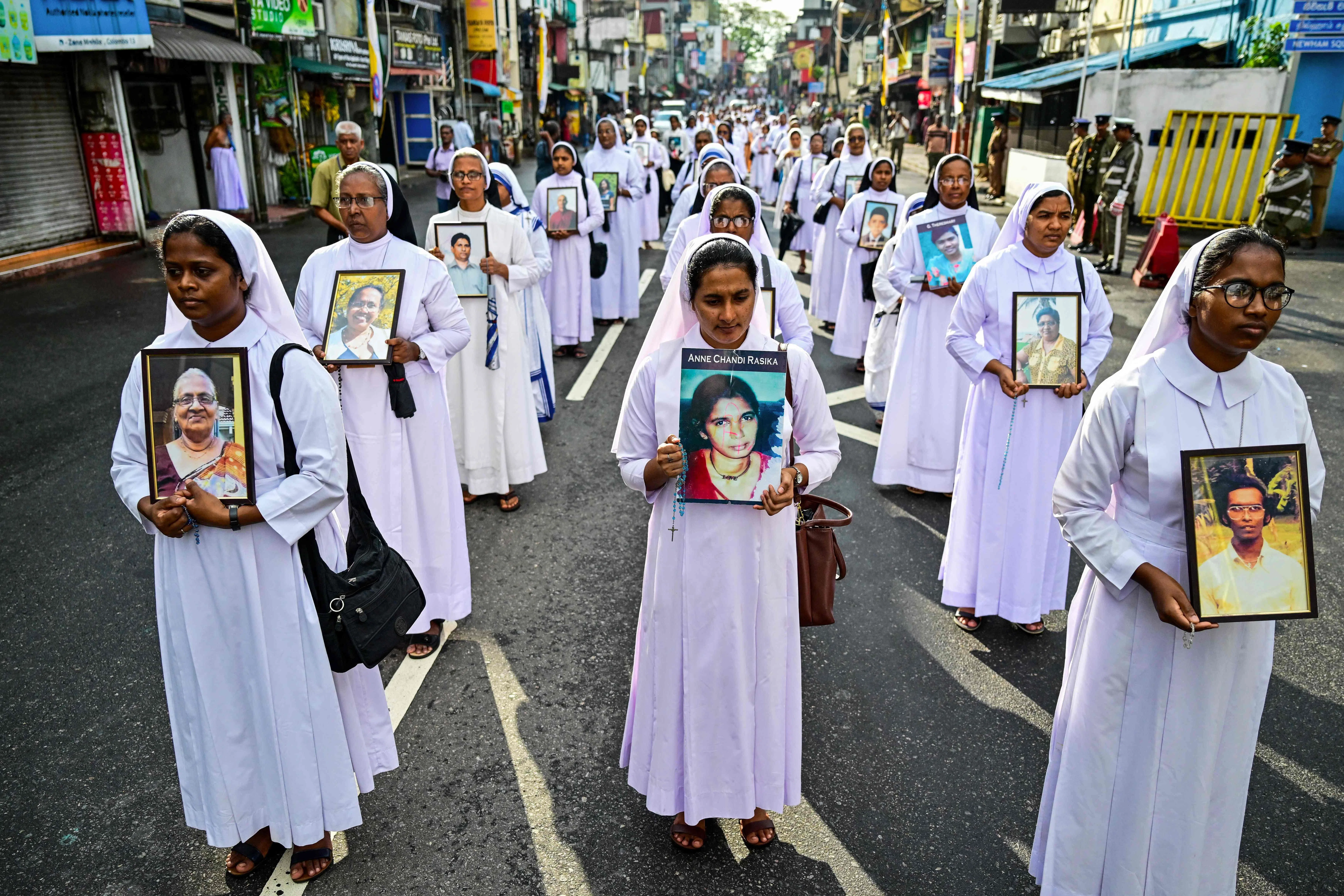 Catholic nuns carrying portraits of victims of the 2019 Easter Sunday bombings at a 2025 commemorative event.