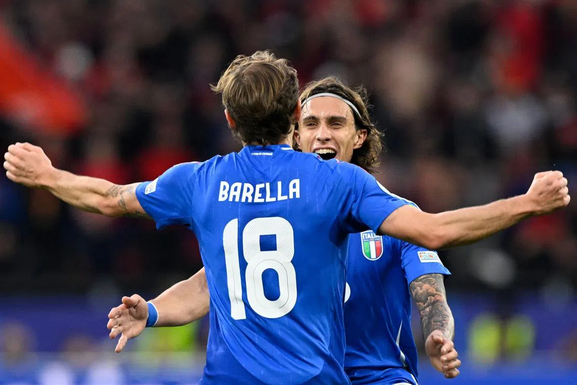 Midfielder Nicolo Barella celebrates with defender Riccardo Calafiori after scoring the winning goal for Italy.