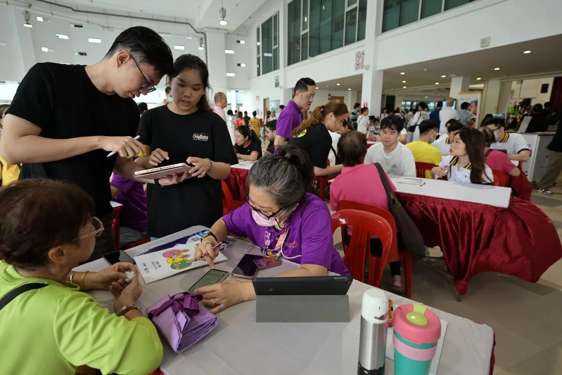 Residents getting help with their digital devices at the official opening of the upgraded Kaki Bukit Community Club on June 8.
