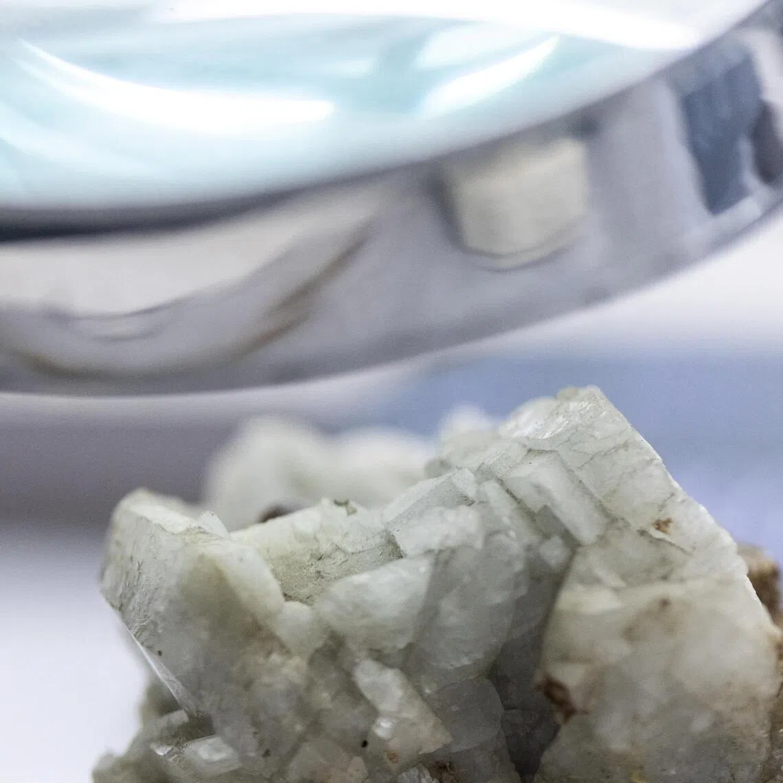 A sample of monazite, a mineral used in the rare earth industry to extract elements such as cerium, lanthanum, and neodymium, is displayed next to a magnification glass at the Geological Museum of China in Beijing on Oct 14, 2025. 