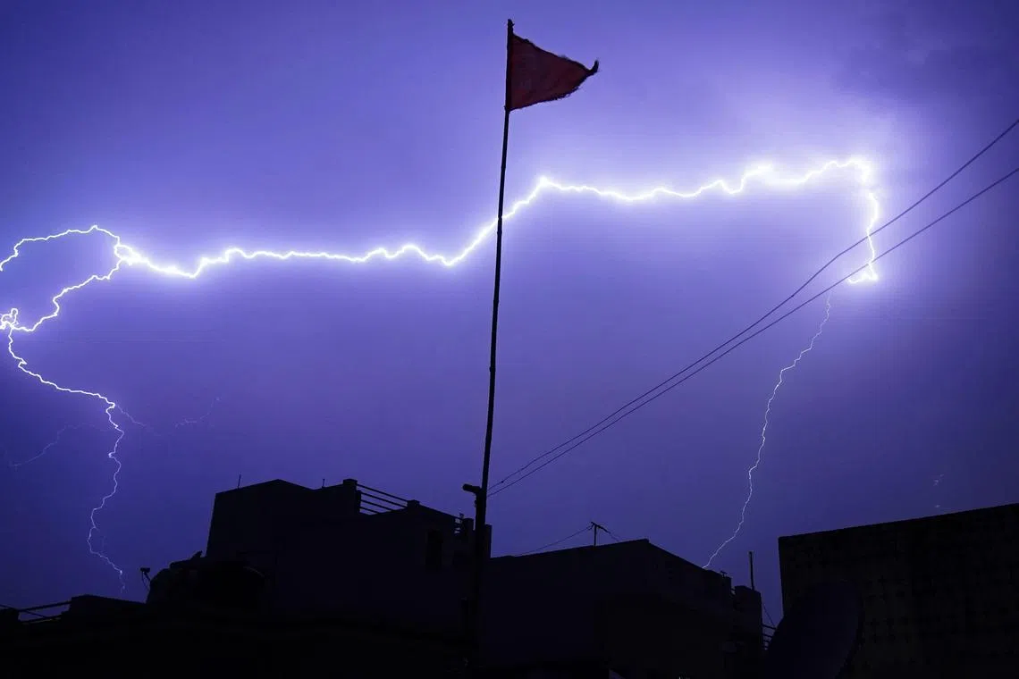 This photograph taken on April 26, 2023 shows a lightning strike during a thunderstorm over the city of Ajmer. (Photo by Himanshu SHARMA / AFP)