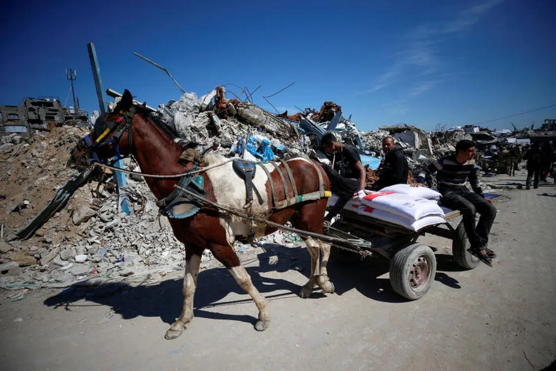 Palestinians transport aid provided by UNRWA including food supplies, on a horse-drawn cart, after Israel says it has ceased entry of humanitarian aid into Gaza, at Jabalia refugee camp in northern Gaza Strip, March 2, 2025. REUTERS/Mahmoud Issa