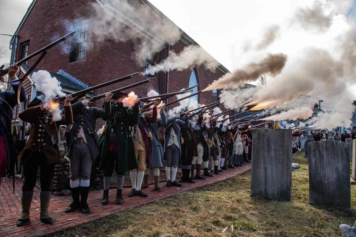 TOPSHOT - US Revolutionary War reenactors fire off volleys at Saint Augustine’s Chapel at the start of the Evacuation Day exercises in Boston, Massachusetts on March 17, 2026. March 17 marks the 250th anniversary of British forces evacuating Boston after the siege of Boston in 1776, during the early part of the American Revolutionary War. (Photo by Joseph Prezioso / AFP)