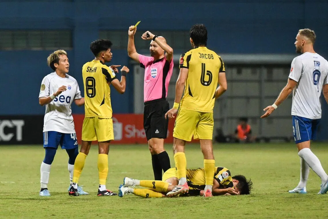 Lion City Sailors midfielder Kyoga Nakamura (in white) being shown a yellow card by referee Jansen Foo, after Nakamura appeared to elbow BG Tampines Rovers' Takeshi Yoshimoto at Jalan Besar Stadium on Feb 22, 2026.