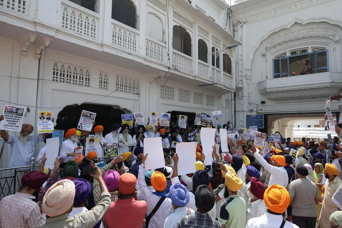 People hold placards protesting the killing of Canadian Sikh separatist leader Hardeep Singh Nijjar at a demonstration outside the Golden Temple in Amritsar on Sept 29, 2023.
