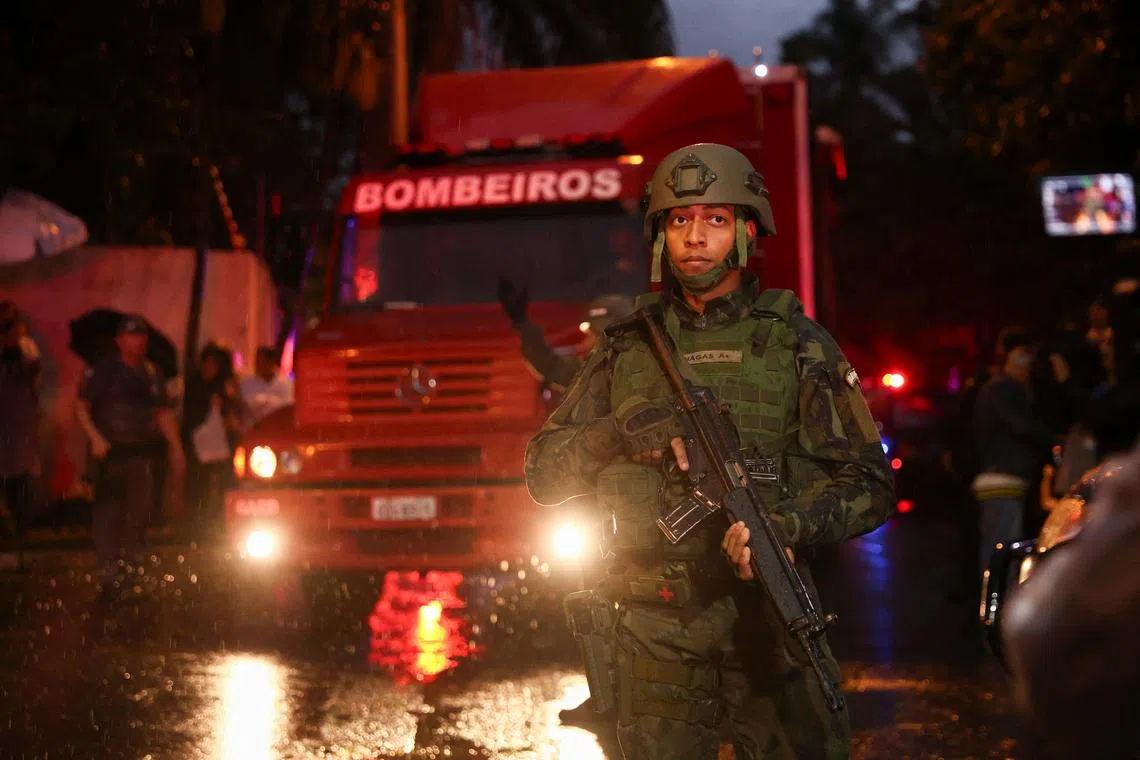 FILE PHOTO: A member of security forces stands while authorities arrive at the site where a turboprop plane crashed killing all passengers and crew on board, in Vinhedo, Brazil August 9, 2024. REUTERS/Carla Carniel/File Photo