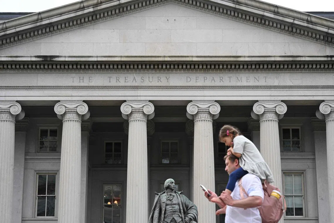 People pass by the Treasury Building on Pennsylvania Avenue in Washington, DC, on May 19, 2023. Republicans have paused crunch US debt default talks less than two weeks before a potentially catastrophic default, House Speaker Kevin McCarthy said Friday, citing lack of movement from Democrats. (Photo by Mandel NGAN / AFP)