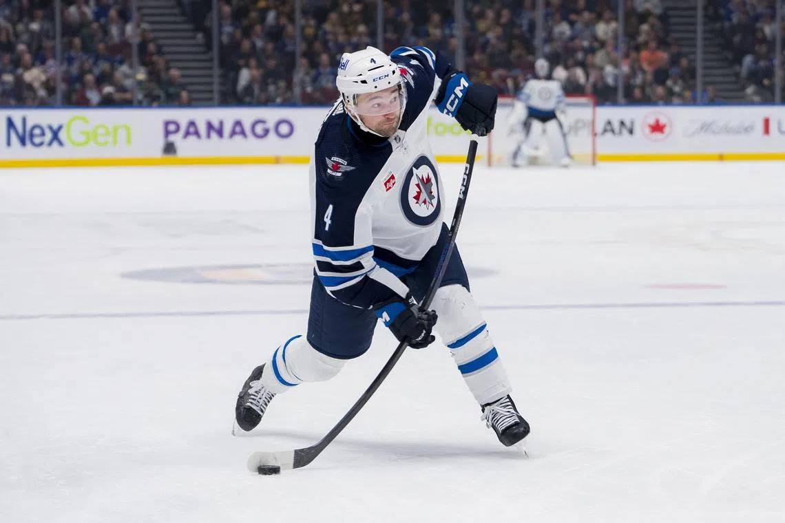 FILE PHOTO: Feb 17, 2024; Vancouver, British Columbia, CAN; Winnipeg Jets defenseman Neal Pionk (4) shoots against the Vancouver Canucks in the third period at Rogers Arena. Bob Frid-USA TODAY Sports/File Photo