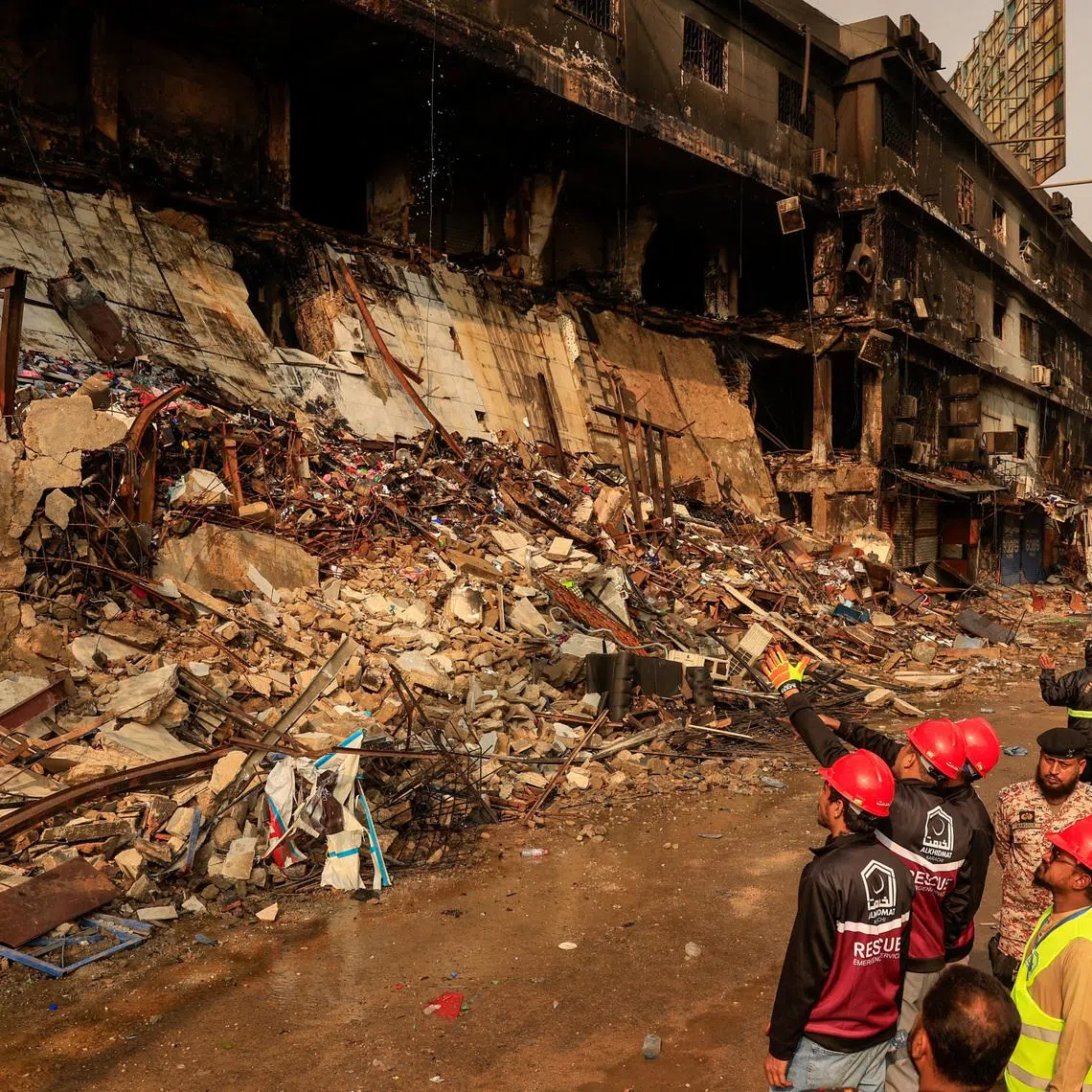 Emergency personnel survey the damaged portion of the building, following a massive fire that broke out in the Gul Plaza Shopping Mall in Karachi, Pakistan, January 19, 2026. REUTERS/Akhtar Soomro