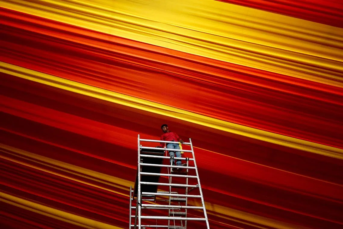 A worker giving final touches to a temporary mega tent amid preparations ahead of India's Prime Minister Narendra Modi's visit in Prayagraj, India, on Dec 9, 2024. 