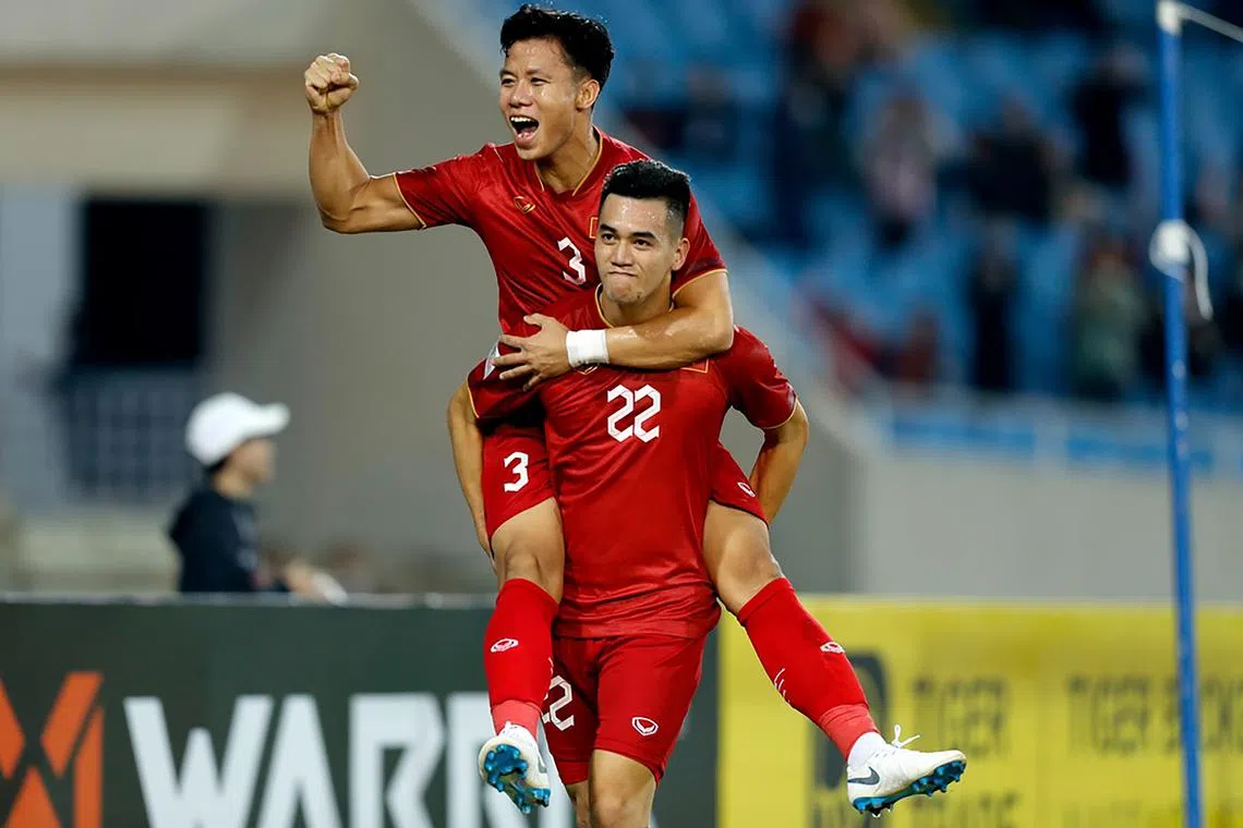 Vietnam's Nguyen Tien Linh carries Que Ngoc Hai.