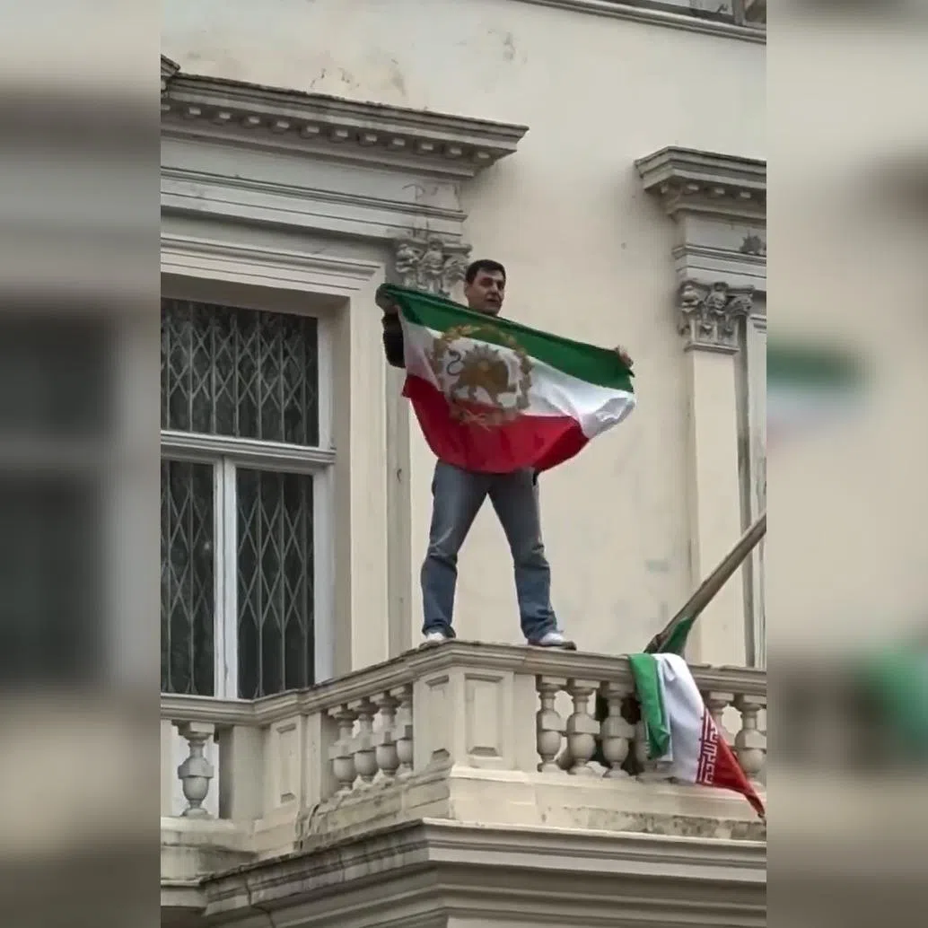 A video posted to social media showed a man on the balcony of the Iranian embassy replacing the country’s current flag with one used during the rule of the ousted shah.