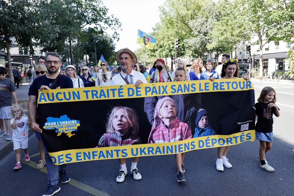 People hold a banner reading "No peace treaty without the return of Ukrainian deported children", during a demonstration in Paris, France, in August 2025.
