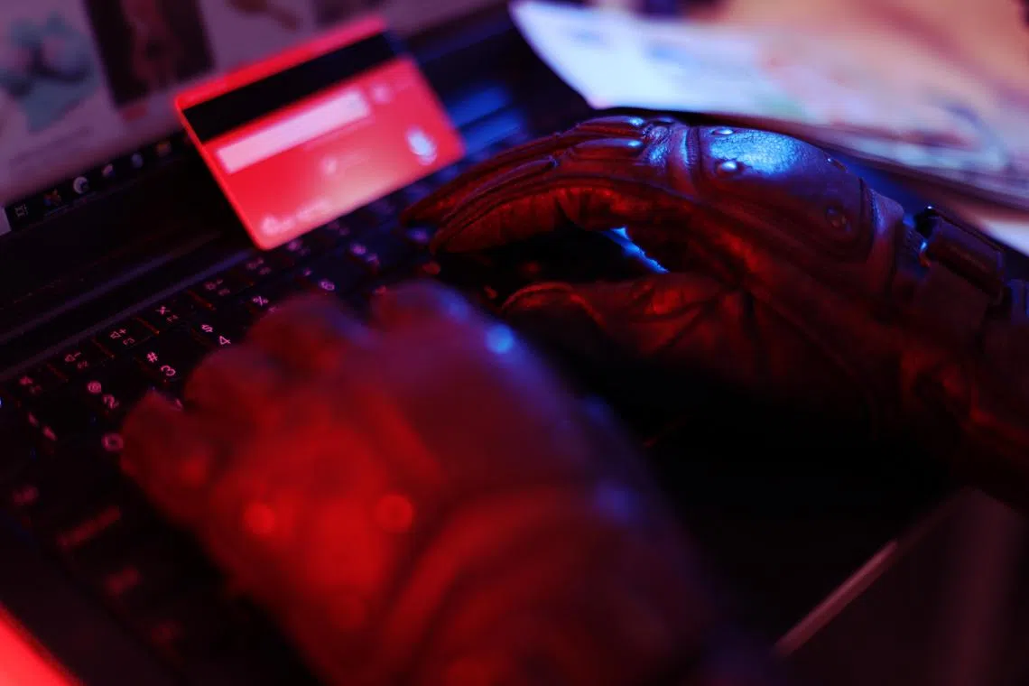 CMG20240627-HengYY01 / 王彦燕 / 犯罪示意图 ：Crime: Cyber crime concept. [SPH] Theif steals money. Business / Man holding money dollars in hand in black gloves.Hacking concept with hand wearing black leather glove. Computer keyboard with hands in black gloves.Data theft stock photo.Hacker hand in glove.Thief stealing data from a laptop.、scam、Online scam, scams, frauds, scammers, phishing, e-commerce scams 、phone scam、work scam 、Singapore dollars、滥用电脑、欺诈、意图、网络、科技犯罪、黑客、诈骗、新币