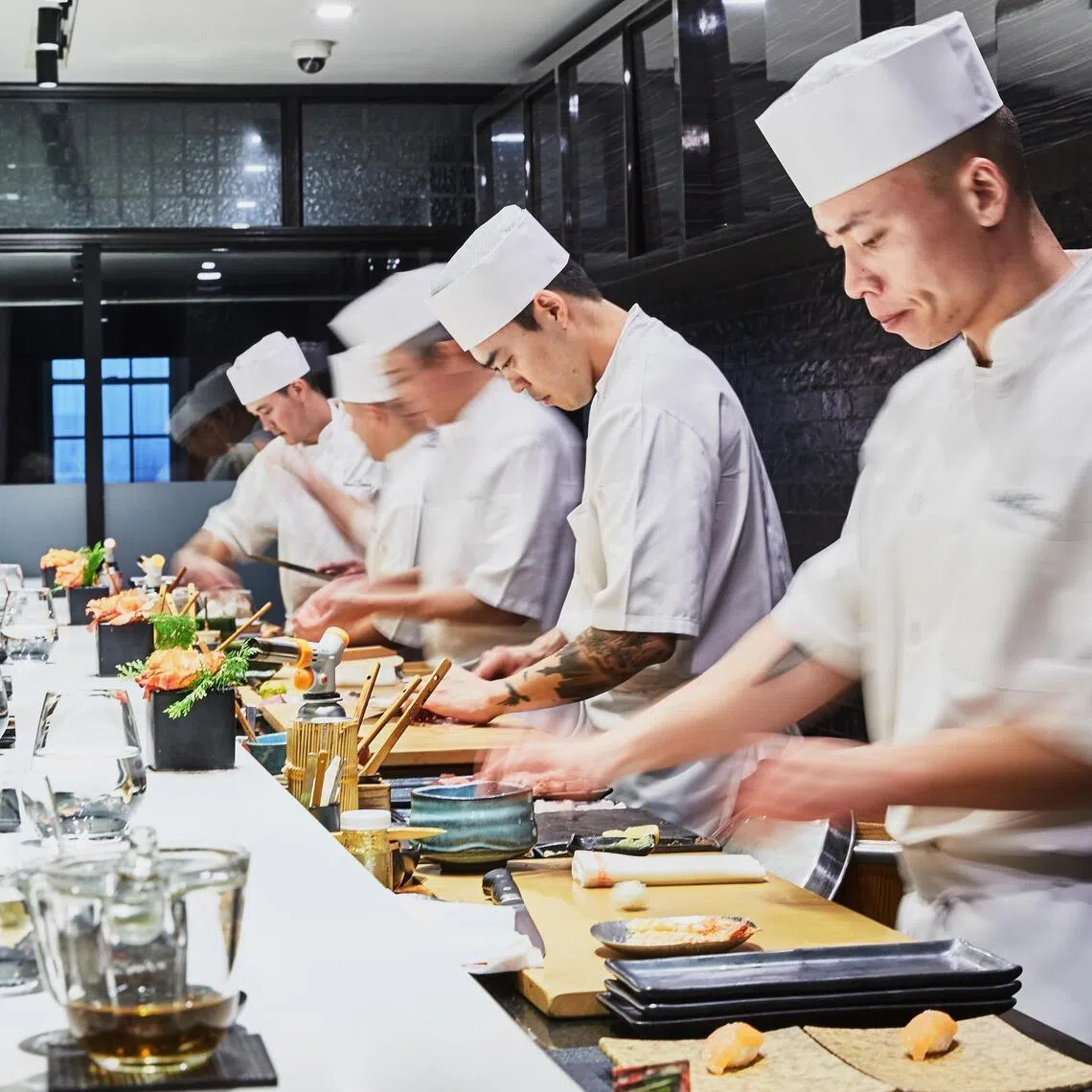 Food is prepared across a white marble counter from diners at Sushi Nakazawa in New York on Dec. 29, 2019. (Ellen Silverman/The New York Times)