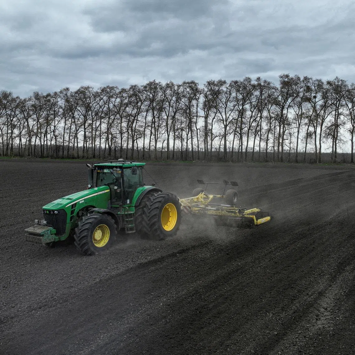 An agriculture worker drives a tractor as he prepares soil for sowing buckwheat in the village of Malopolovetske, amid Russia's attack on Ukraine, in the Kyiv region, Ukraine, April 6, 2026. REUTERS/Valentyn Ogirenko