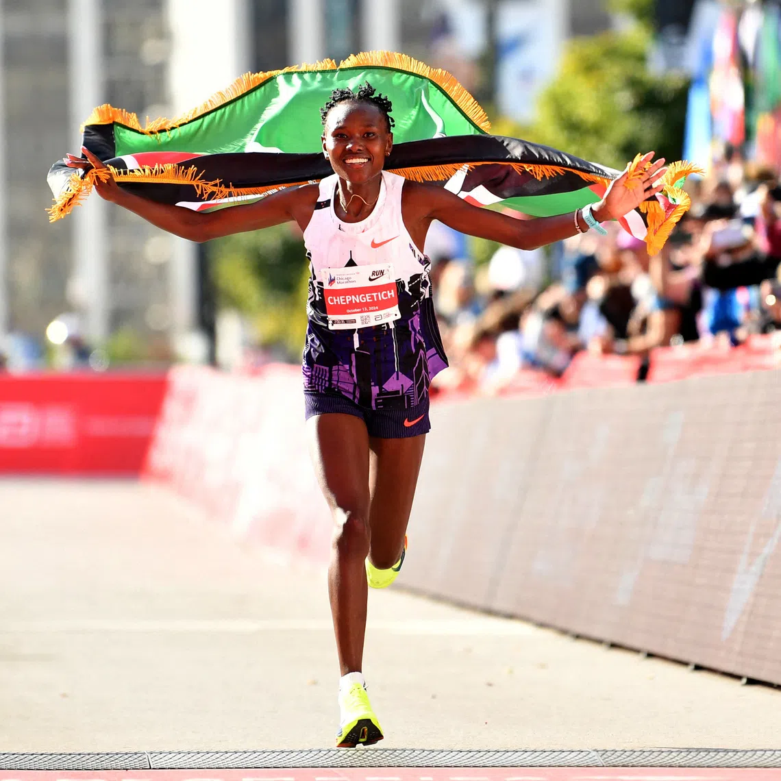 Oct 13, 2024; Chicago, IL, USA; Ruth Chepngetich of Kenya celebrates after finishing first in the women’s race, setting a new world record at 2:09:56 during the Chicago Marathon at Grant Park. Mandatory Credit: Patrick Gorski-Imagn Images