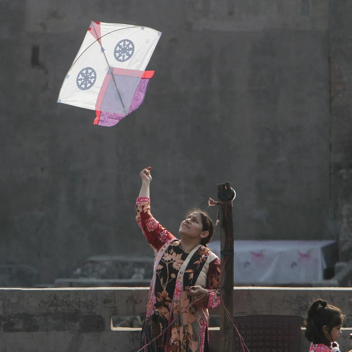 A woman flies a kite from a rooftop to mark Basant, a kite-flying festival, in Lahore, Pakistan February 6, 2026. REUTERS/Mohsin Raza