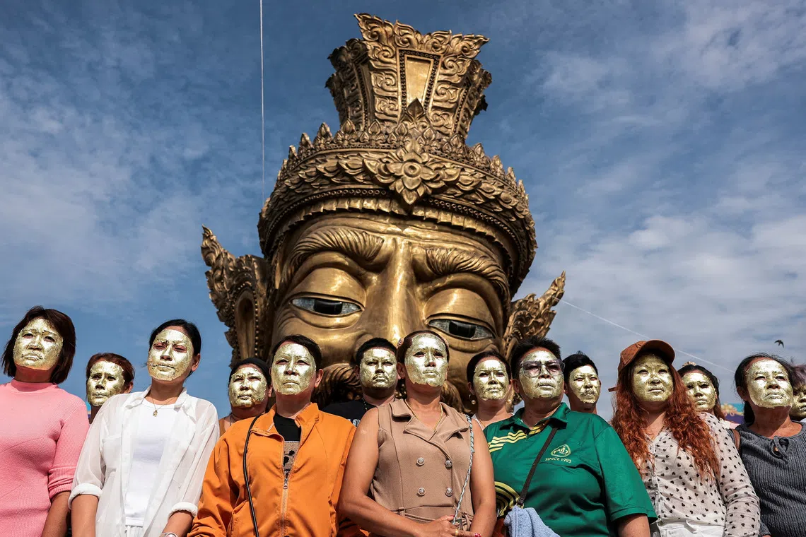 Devotees with their faces covered in gold leaves pose for a picture in front of a statue of Por Kae during a "Na Na Thong", or Gold Leaf Face-Blessing ritual, a sacred ritual believed to enhance wealth and fortune, at a shrine in Ayutthaya province, Thailand, August 30, 2026. REUTERS/Chalinee Thirasupa TPX IMAGES OF THE DAY