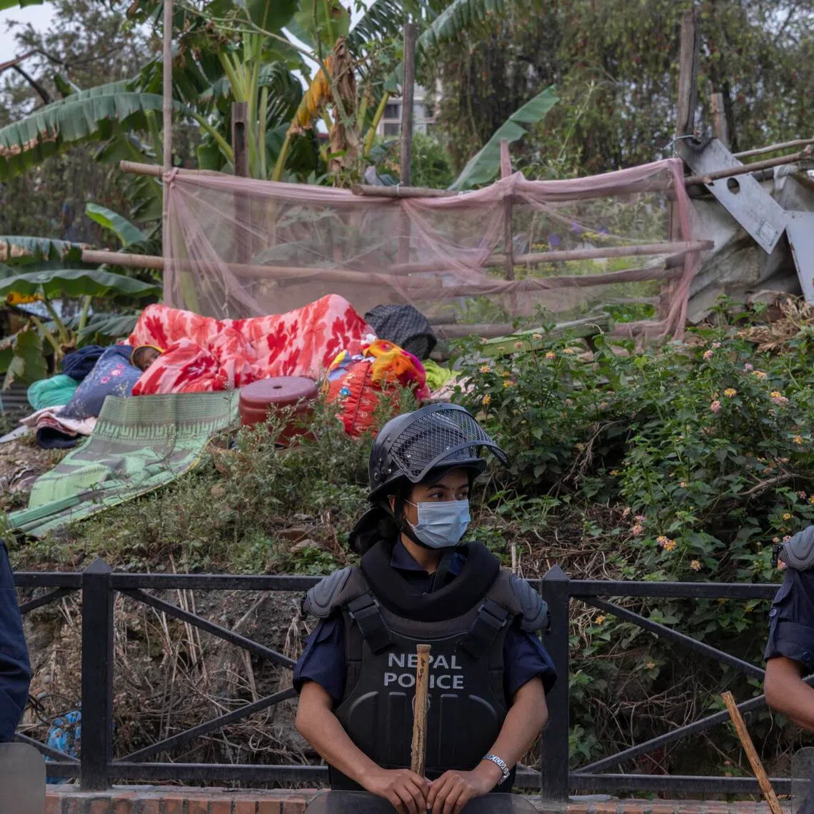 Nepalese police stand guard as the Nepal government begins demolition of riverbank squatter settlements in Kathmandu, Nepal, on April 25.
