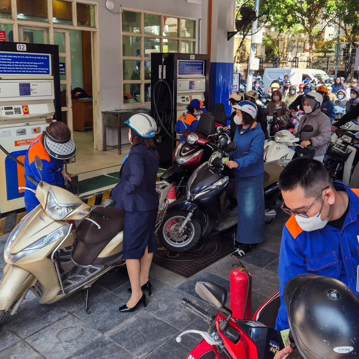 People queue to buy petrol at a petrol station after Vietnam's trade ministry called on local businesses to encourage their employees to work from home to save fuel, in Hanoi, Vietnam