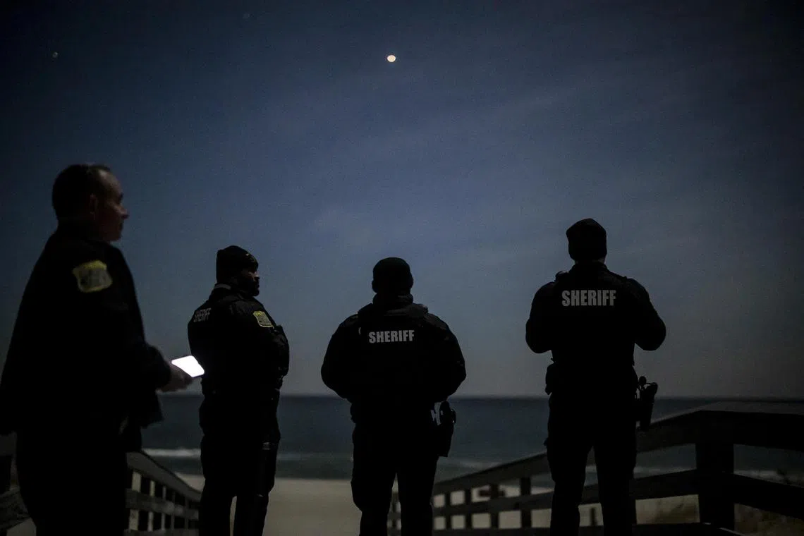 Sheriff officers scan the night sky for drones at Island Beach state park in New Jersey.