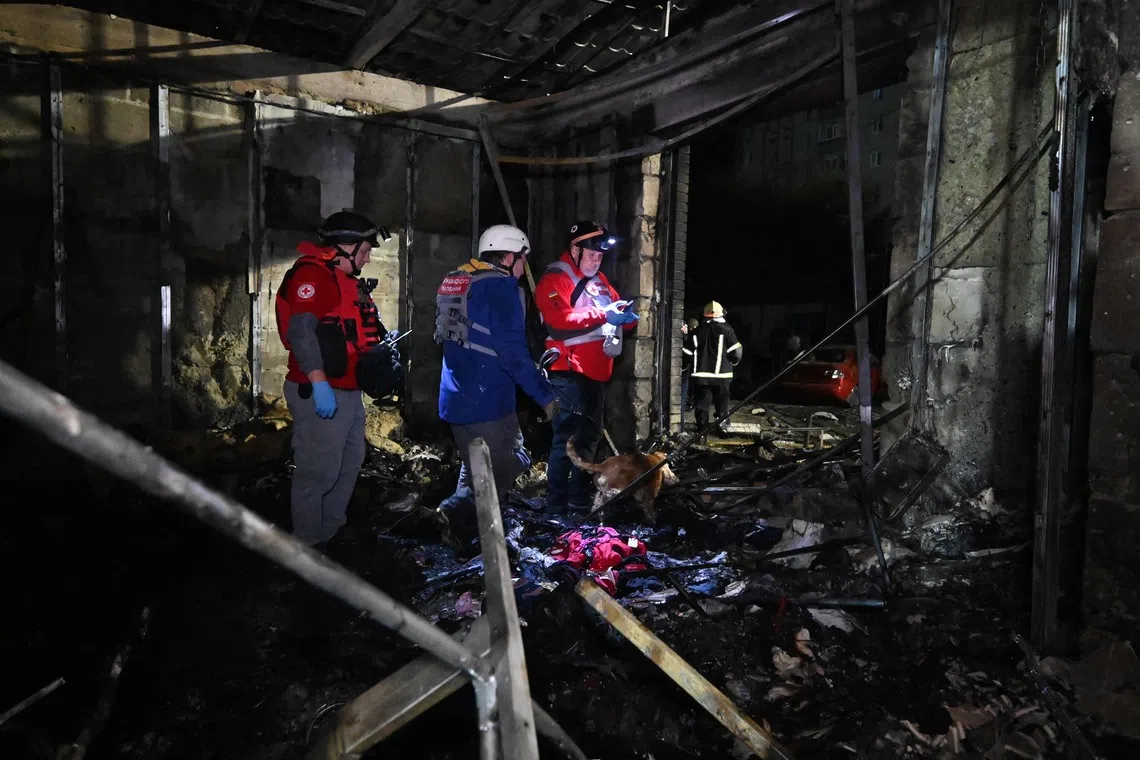 Rescuers work in a shop destroyed following a Russian missile attack in Pesochin settlement, a suburb of Kharkiv, which killed three people and wounded 22, on Oct 11.