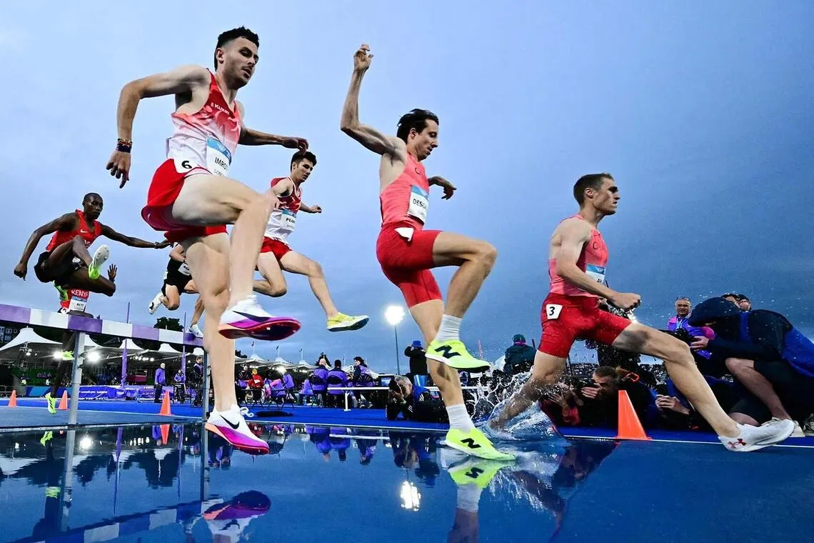 TOPSHOT - England's Kristian Imroth (L) and Canada's Jean-Simon, Desgagnes (C) compete in the men's 3000m steeplechase final during the athletics event at the Scotstoun Stadium in Glasgow, on day four of the Commonwealth Games in Glasgow, Scotland, on July 27, 2026. (Photo by Ben STANSALL / AFP)