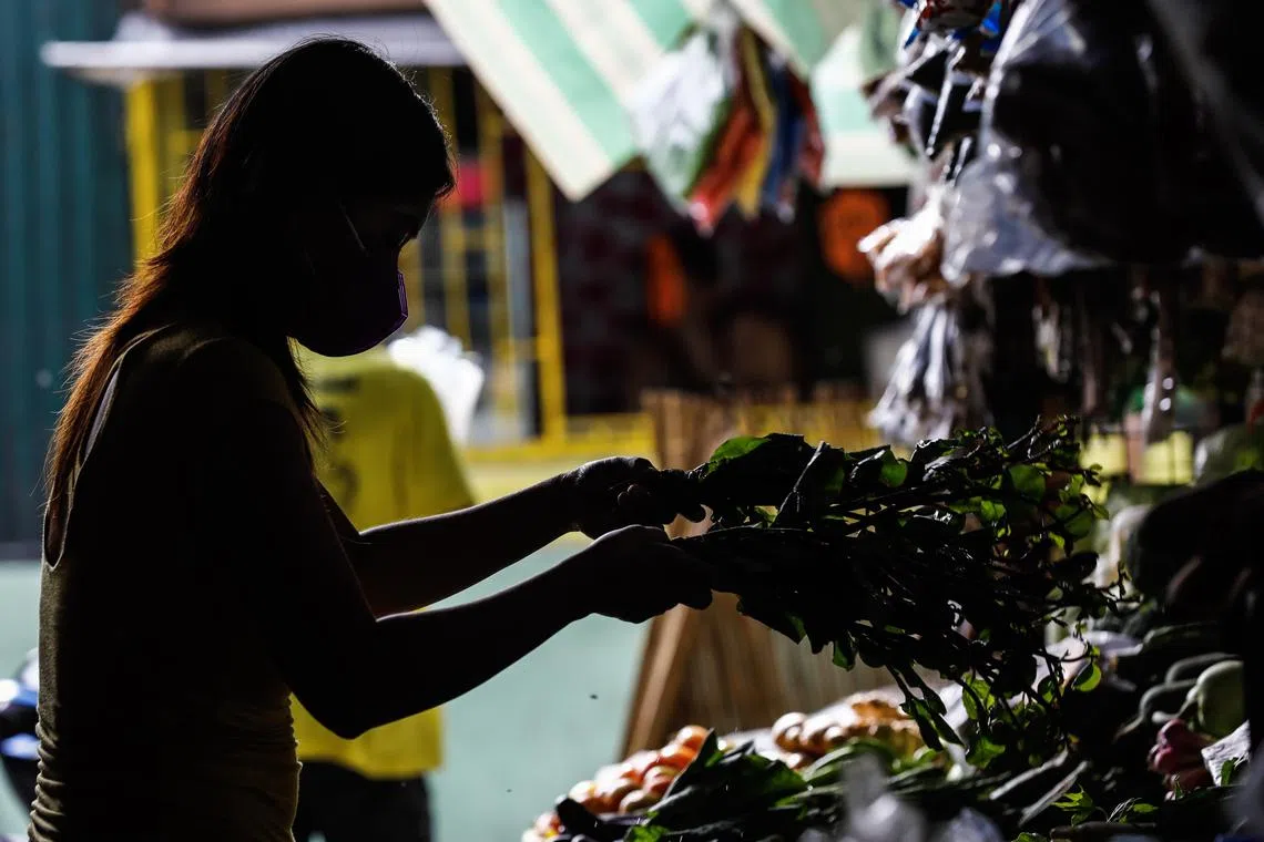 A vendor prepares vegetables for sale at in Quezon, Philippines, on Jan 26, 2023. 