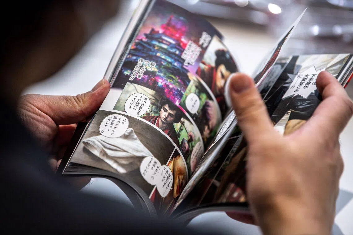 This picture taken on March 2, 2023 shows the acting chief Masakado Kunisawa checking copies of "Cyberpunk: Peach John", Japan's first fully AI-drawn manga, at the office of comic book publisher Shinchosha in Tokyo. - The author of a sci-fi manga about to hit shelves in Japan admits he has "absolutely zero" drawing talent, so turned to artificial intelligence to create the dystopian saga. All the futuristic contraptions and creatures in "Cyberpunk: Peach John" were intricately rendered by Midjourney, a viral AI tool that has sent the art world into a spin, along with others such as Stable Diffusion and DALL-E 2. (Photo by Philip FONG / AFP) / TO GO WITH: Japan-tech-culture-manga-AI, FOCUS by Tomohiro OSAKI
