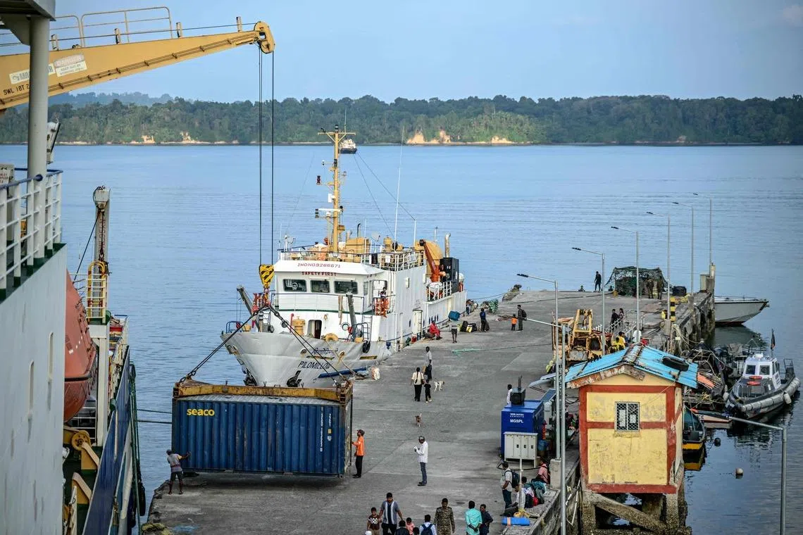 Workers unloading shipping containers from the Nalanda passenger vessel at Kamorta in India's Andaman and Nicobar Islands on March 25.