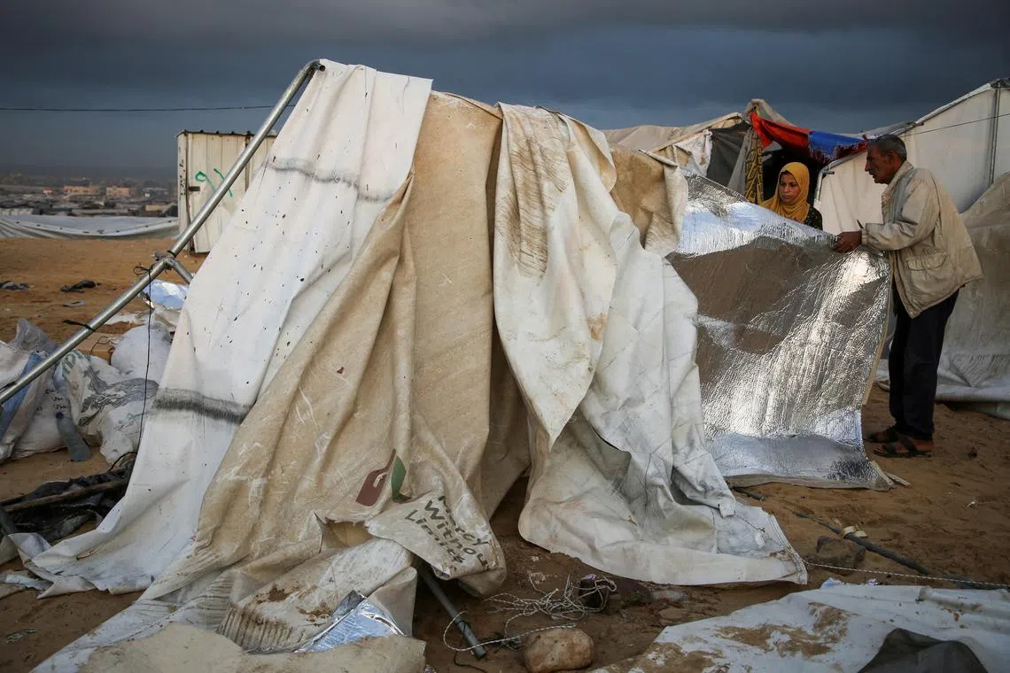 Palestinians inspect the damage at the site of an Israeli strike on a tent camp sheltering displaced people, amid the ongoing Israel-Hamas conflict, in Al-Mawasi area in Khan Younis, in the southern Gaza Strip, October 15, 2024. REUTERS/Hatem Khaled