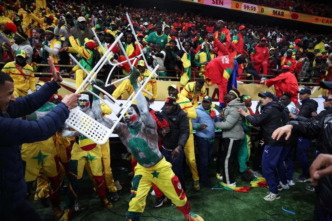 A Senegal fan clashing with security as supporters invade the pitch after Morocco were awarded a penalty following a VAR review in the Africa Cup of Nations final at the Stade Prince Moulay Abdallah in Rabat on Jan 18.  Senegal eventually won the match 1-0 in extra time.