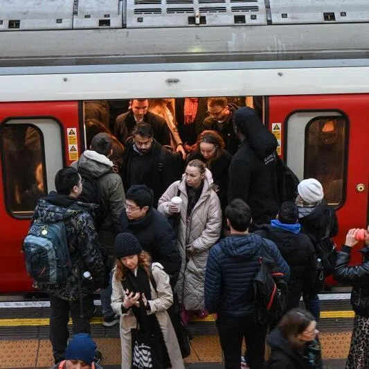Commuters on the platform at Earls Court Tube station in London.  
