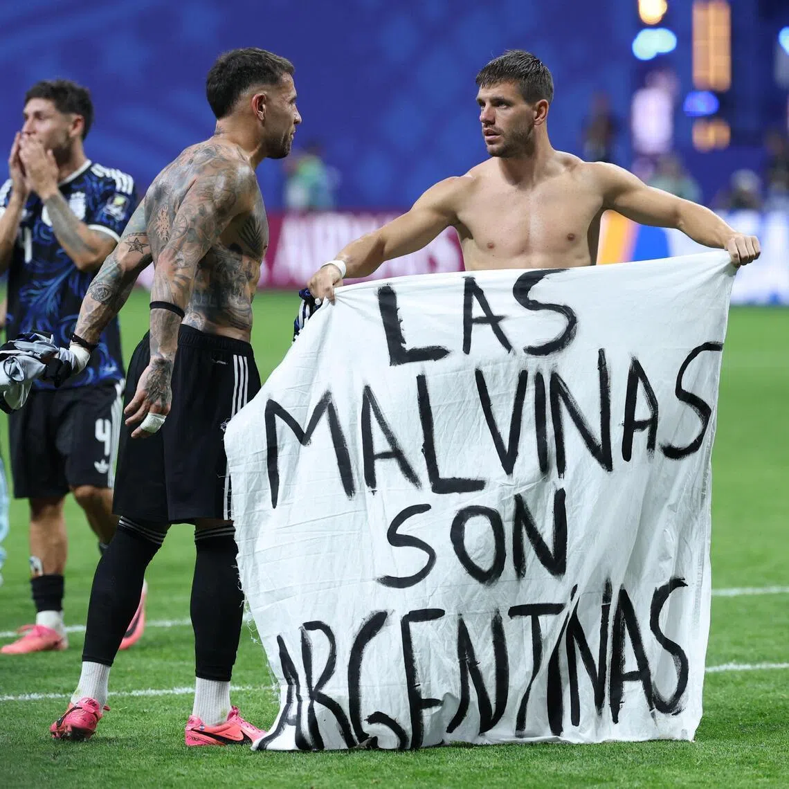 Argentina defender Nicolas Otamendi (left) and midfielder Giovani Lo Celso displaying a banner that reads in Spanish, “The Malvinas (Falkland Islands) belong to Argentina,” after winning their World Cup semi-final match against England on July 15.
