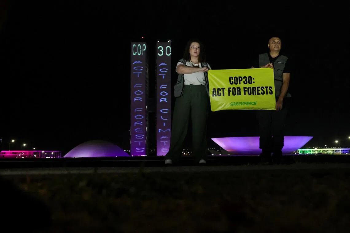 Greenpeace activists hold a sign reading "COP 30: Act for forests" to urge COP30 negotiators to protect forests and the Amazon as part of efforts to combat the climate crisis, outside Brazil's National Congress, in Brasilia, Brazil, October 11, 2025. REUTERS/Adriano Machado