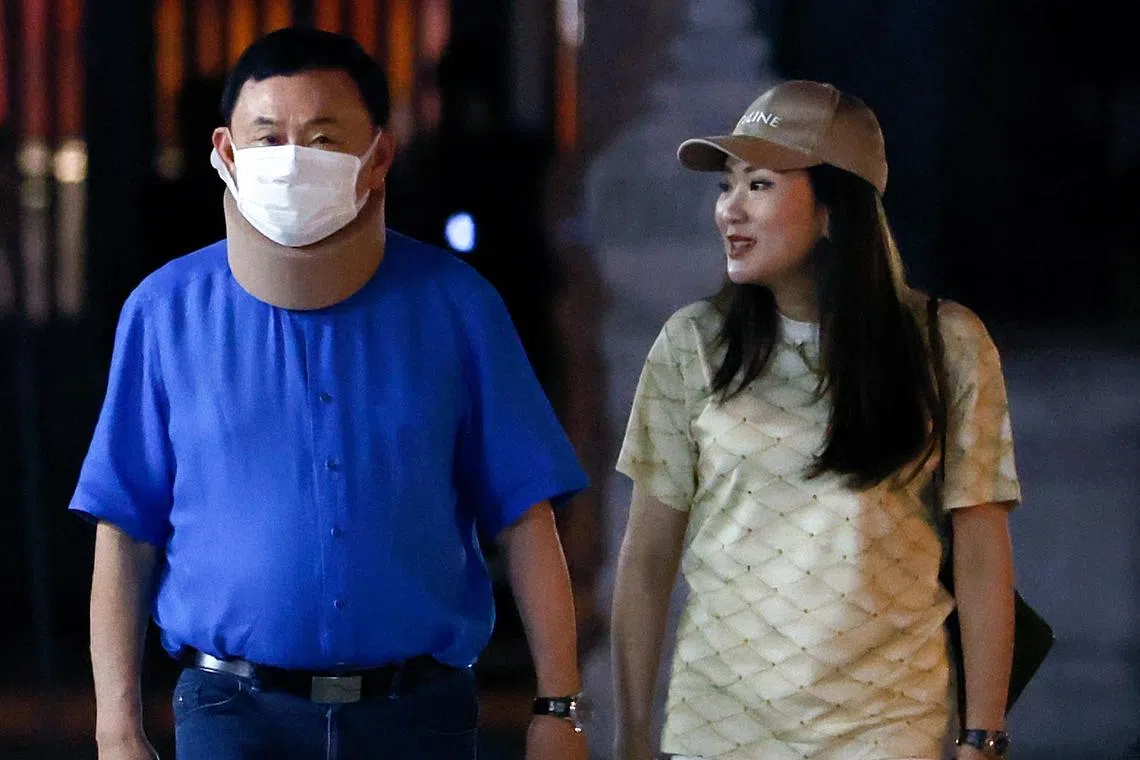 Mr Thaksin, accompanied by his youngest daughter Paetongtarn Shinawatra (left), arrive to worship at the Bangkok City Pillar shrine, on March 14.