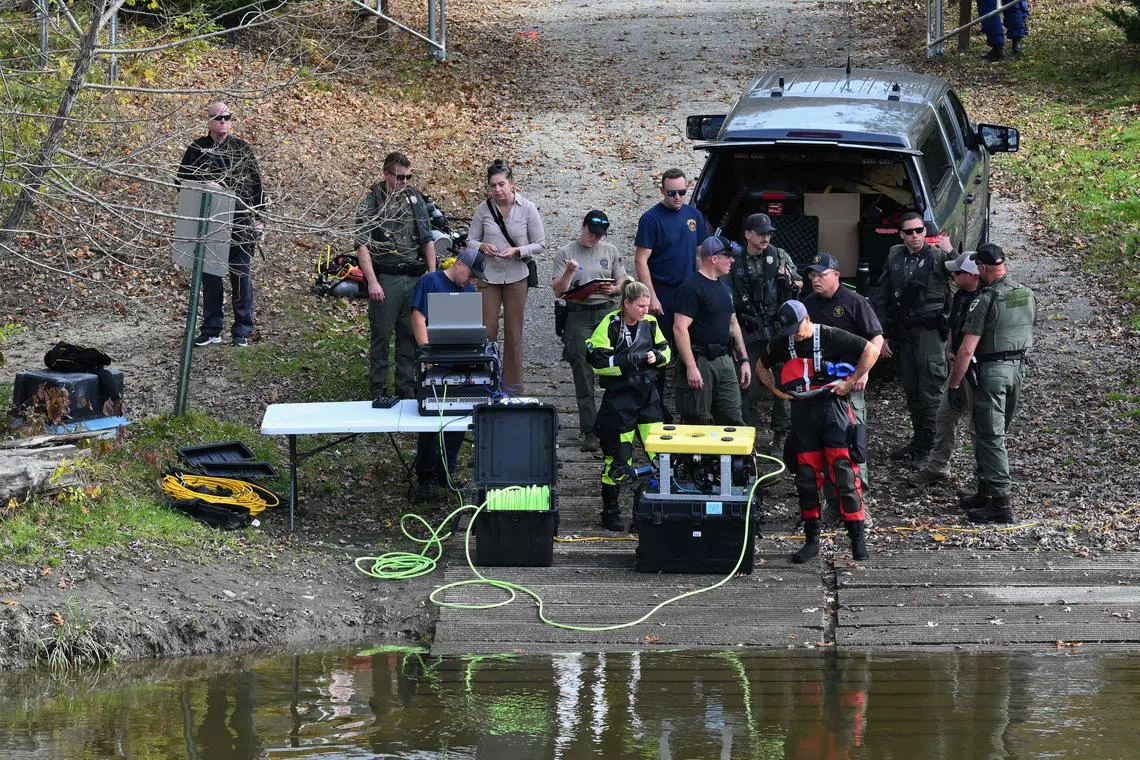 Law enforcement officials prepare to search the Androscoggin River in Lisbon Falls, Maine.