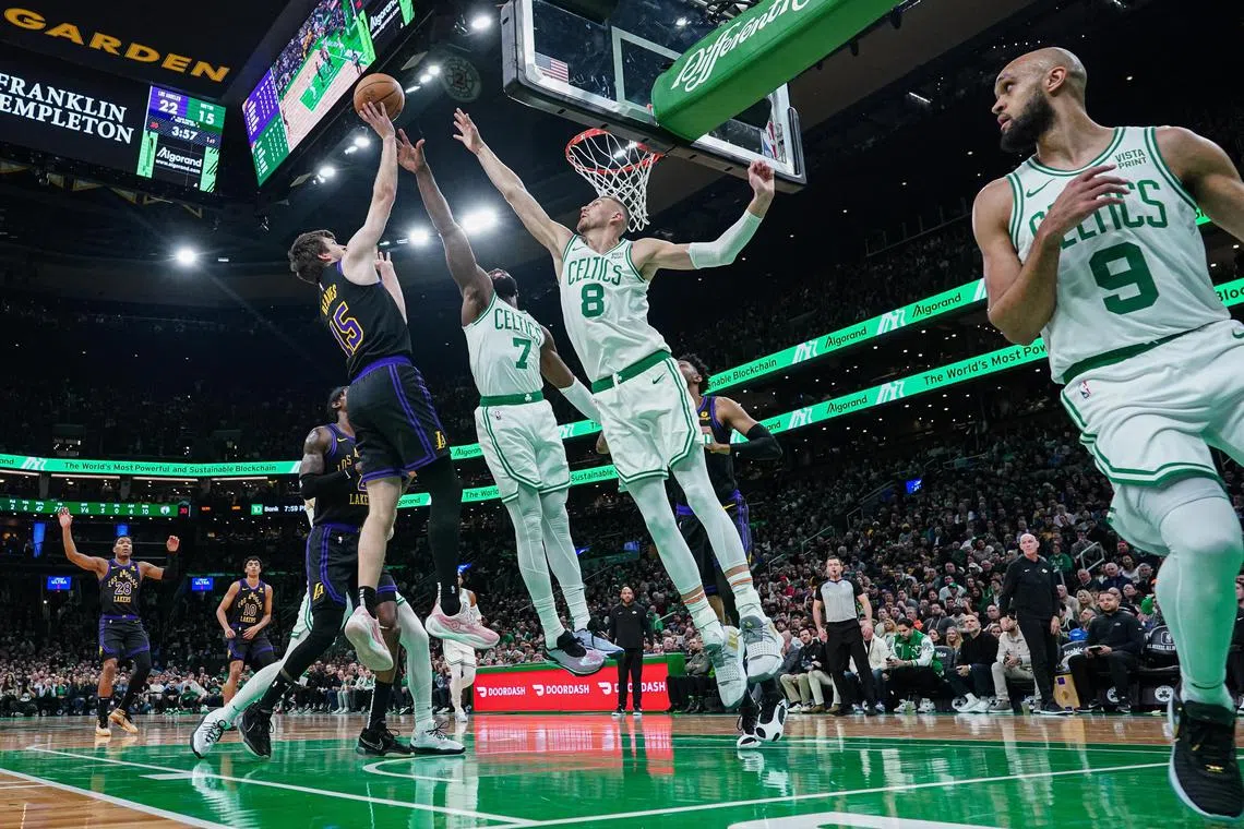Los Angeles Lakers guard Austin Reaves shoots against Boston Celtics centre Kristaps Porzingis and guard Jaylen Brown in the first half at TD Garden.